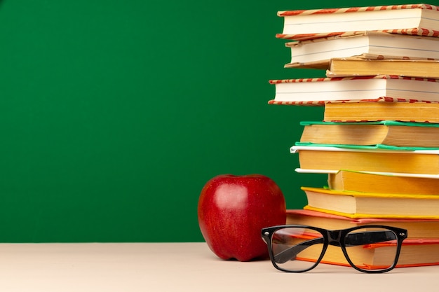 책과 책상에 빨간 사과 더미입니다. 학교 개념으로 돌아 가기