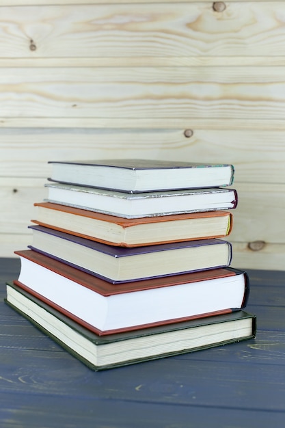 Photo a pile of books with library on the back wallpaper