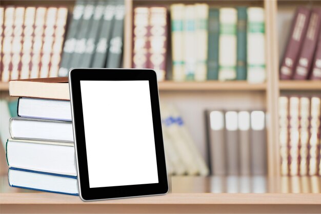 Photo pile of books with modern tablet pc isolated