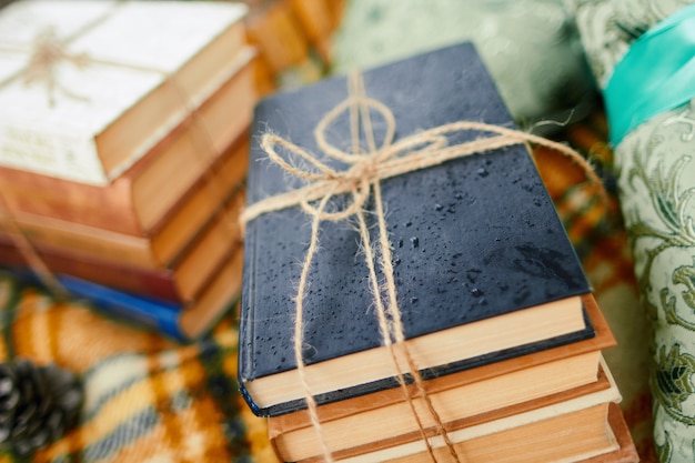 Photo pile of books with rain drops bounding by cord