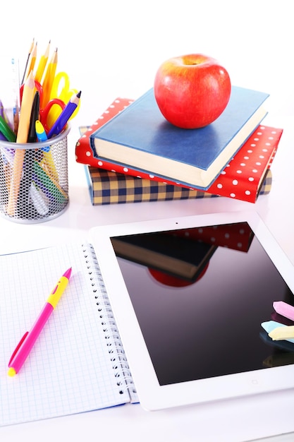 Foto pila di libri con tablet su sfondo bianco