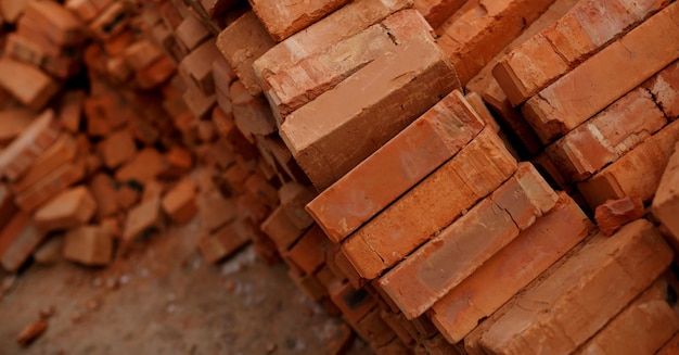 住宅建築現場で工業用に使用されるレンガブロックの山固体粘土レンガ