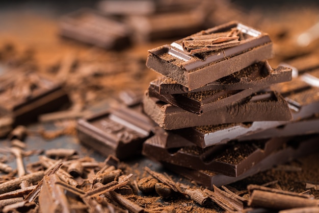 Photo pile of broken dark chocolate on table