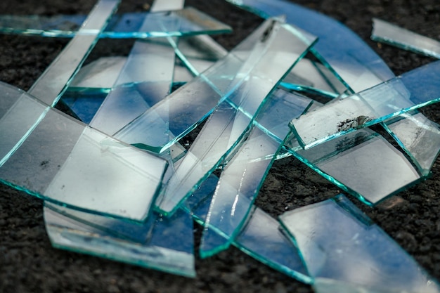 A pile of broken glass lying on the asphalt