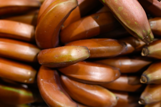 A pile of brown fruits bananas as background