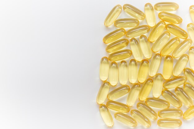 Pile of capsules Omega 3 on white background. Close-up, top view, copy space for your text.