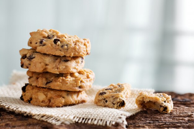 Pile of chocolate chip cookies on wooden desk.