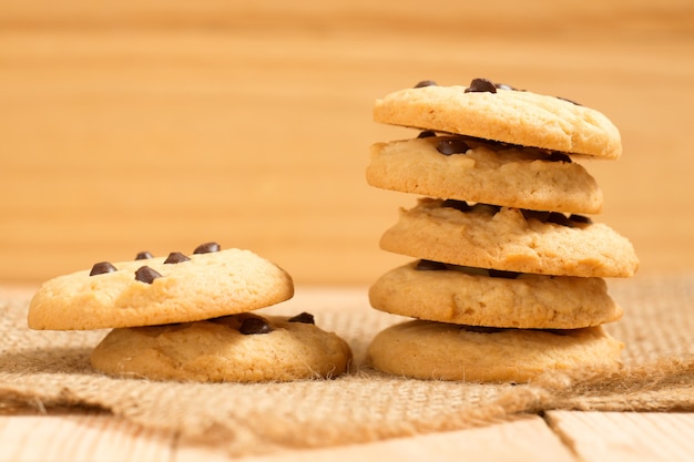 Pile of chocolate chip cookies on wooden table