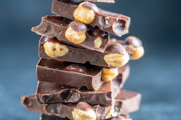 Pile chocolate with nuts on the gray background, close up