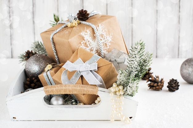 Pile of christmas gift box with decorations on a wooden tray