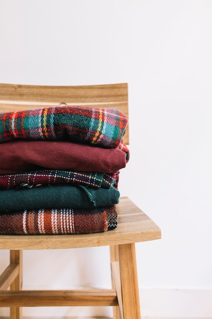 Pile of Christmas sweaters on wooden chair