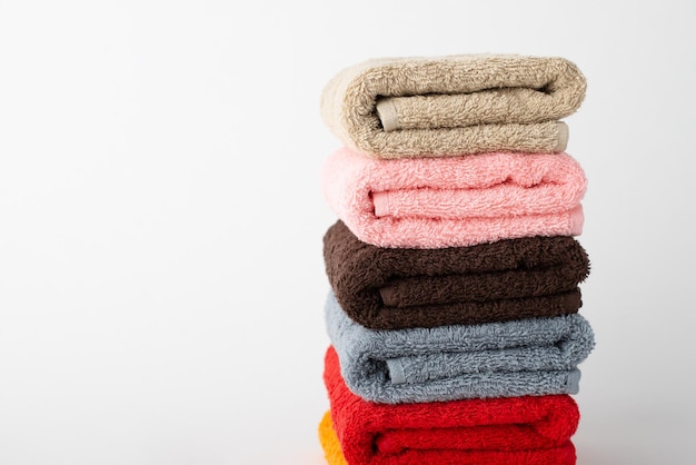 Pile of clean terry bath colorful towels isolated on a white background