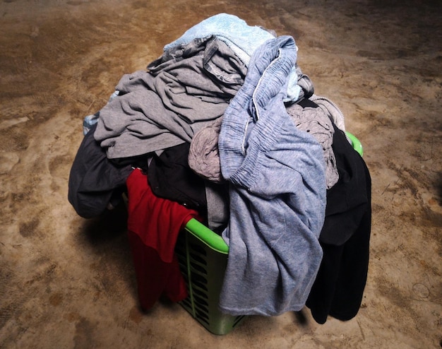 Photo pile of clothes in basket on floor