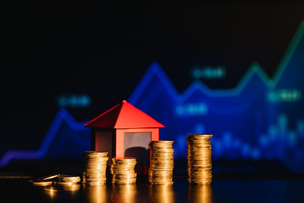 A pile of coins casting a shadow as house, savings concept