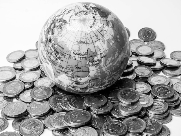 Pile of coins with world planet globe monochrome Concept of saving the planet