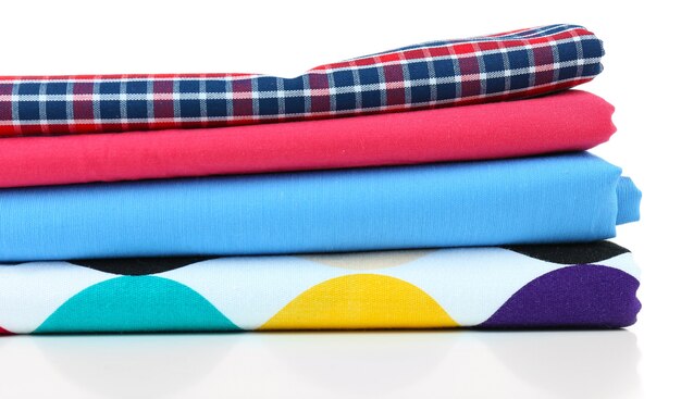 Photo pile of colored fabrics on white