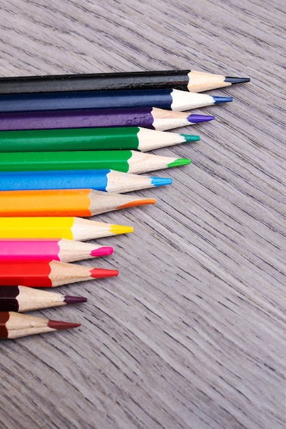 Pile of colored pencils on wooden background