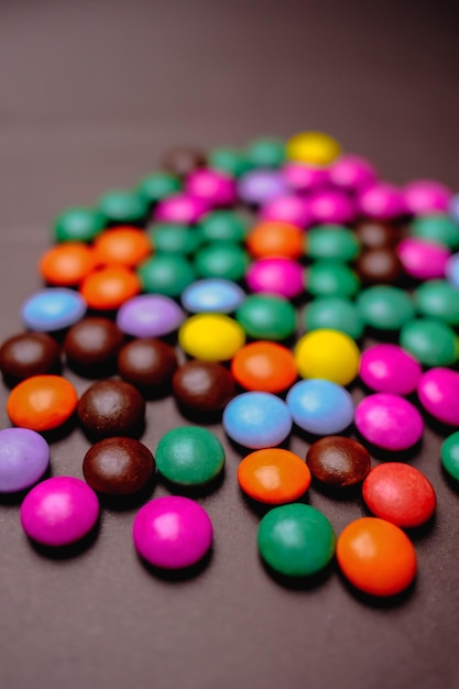 A pile of colorful m & m candy is on a table.