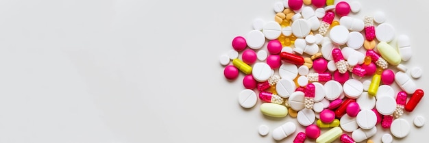 Pile of colorful medicine pills vitamins on white background top viewselective focus Tablets pharmacy conceptdrugs pills heapMedication treatment pharmacy and medicinecopy space