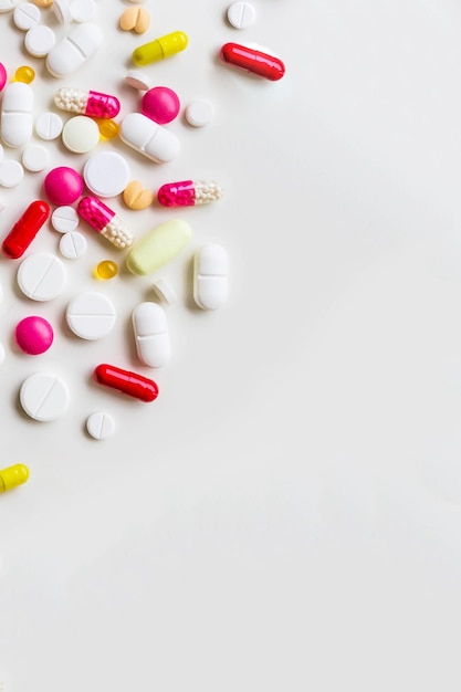 Pile of colorful medicine pills on white background top viewselective focusGlobal healthcare concept Antibiotics drug resistance Antimicrobial capsule pills Pharmaceutical industrycopy space