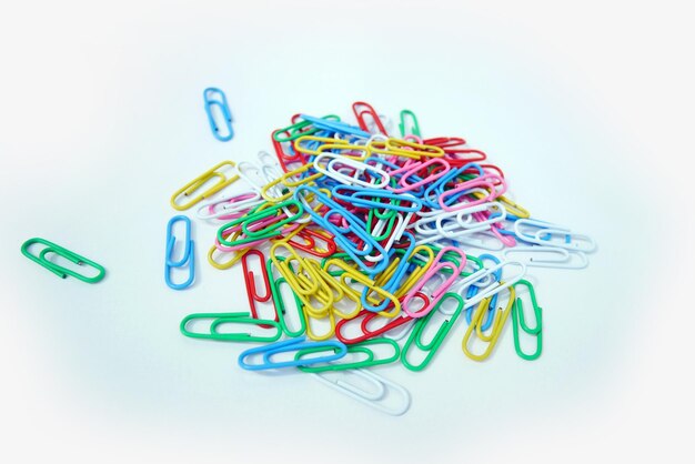 A pile of colorful paper clips are piled up on a white background.