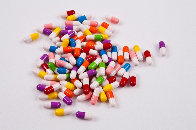 A pile of colorful pills are on a white background