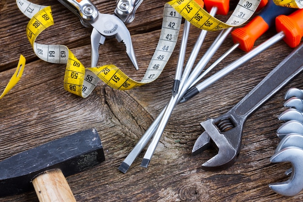 Photo pile of colorful tools with hammer  on wooden  background