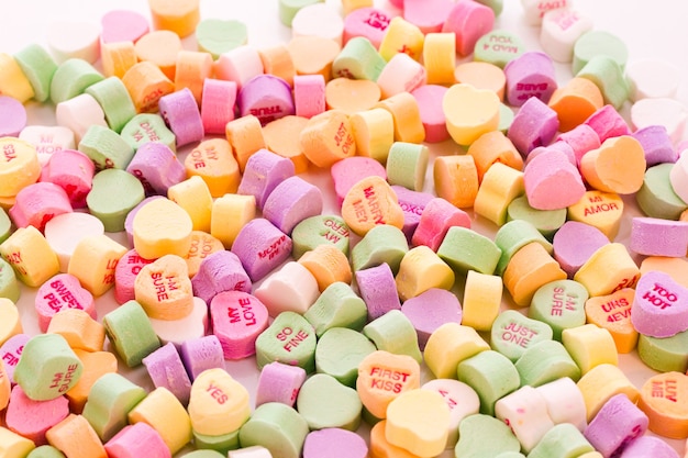 Pile of conversation heart candies on white background.