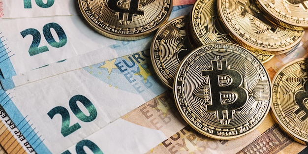 Pile of cryptocurrency Bitcoins on top of Euro banknotes