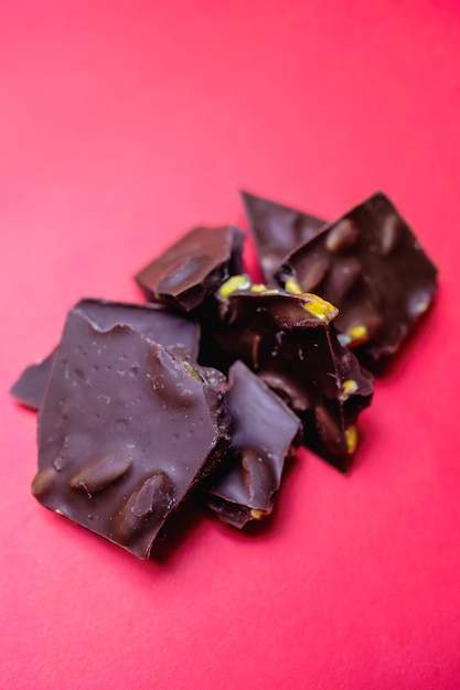 a pile of dark chocolate pieces on a red background.