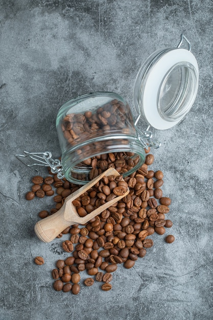 Pile of dark roasted coffee beans on marble surface