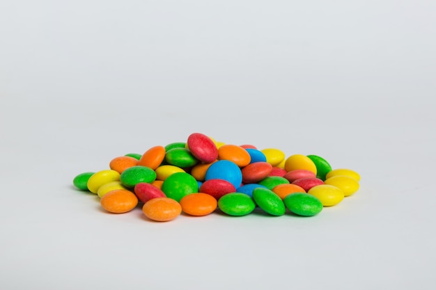 Pile of delicious colorful sweet candies on colored background top view Confectionery decor