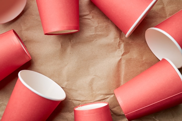 pile of disposable red paper cups on paper. eco friendly concept. look from above. backdrop