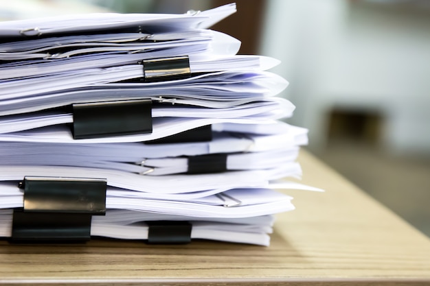 Photo pile of documents on desk.