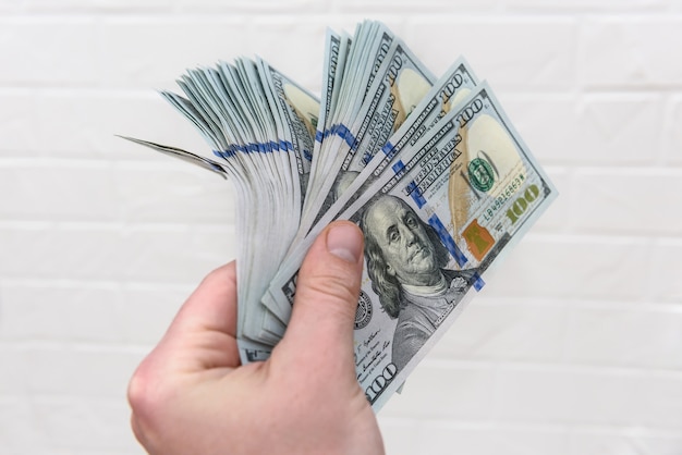 Pile of dollar banknotes on male's palm isolated on white