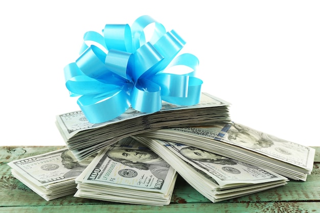 Pile of dollars with bow as gift isolated on white surface