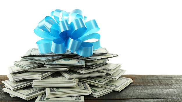 Pile of dollars with bow as gift isolated on white