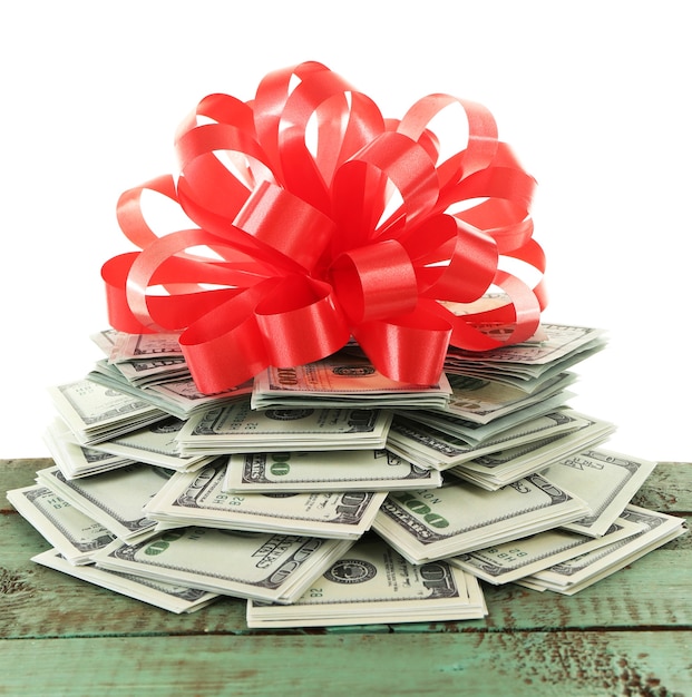 Pile of dollars with bow as gift isolated on white