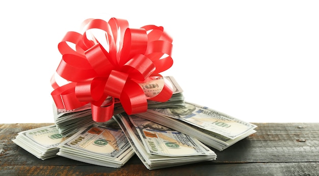 Pile of dollars with bow as gift isolated on white