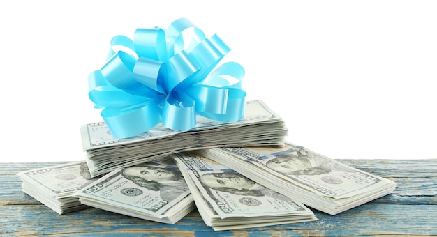 Pile of dollars with bow as gift isolated on white