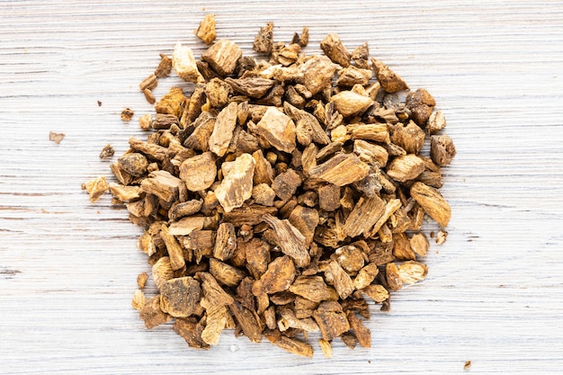 Pile of dried burdock roots on gray wooden board