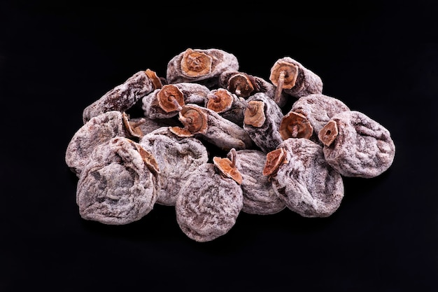 A pile of dried fruits on a black background.