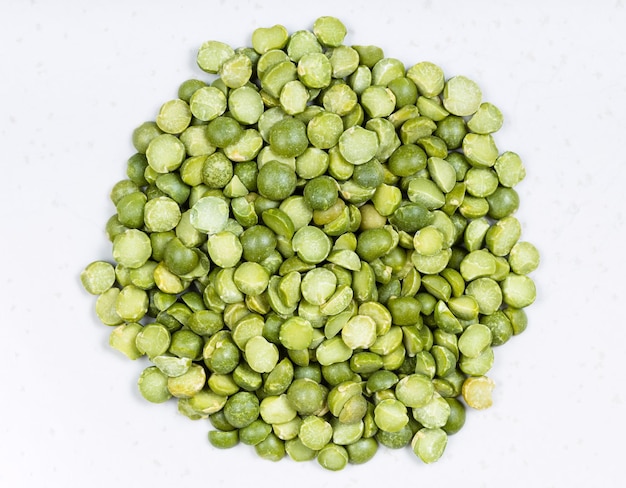 Pile of dried green split peas close up on gray