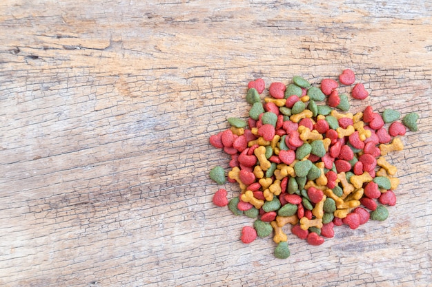 Pile of dry dog food on wooden background. 