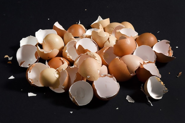 Pile of eggshells on black background