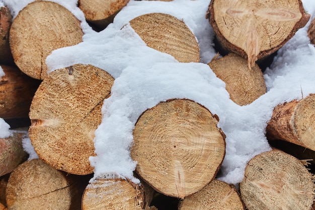 Куча дров фон Дрова сложены в кучу снега на улице Зимняя погода идет снег