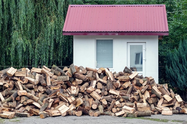 A pile of firewood for heating in winter in the yard of the farm