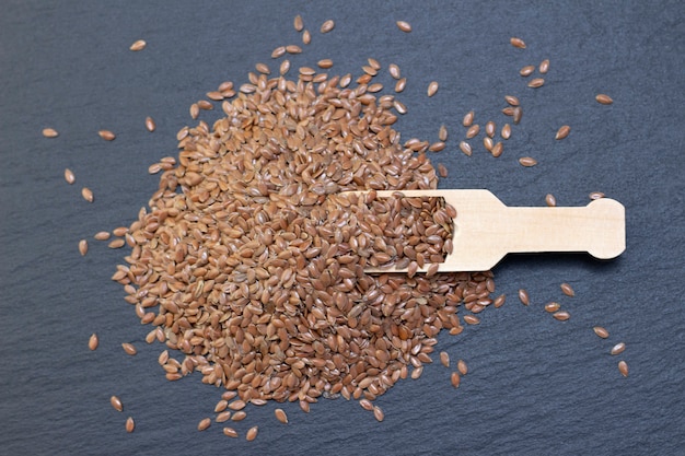 A pile of flax or flax seeds in a wooden spoon