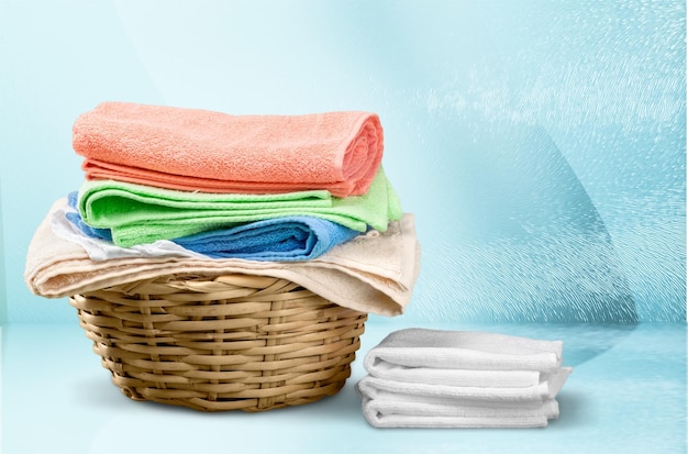 Pile of fluffy towels on light background