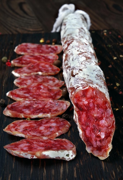 A pile of food on a wooden board with a pepper and pepper on it.